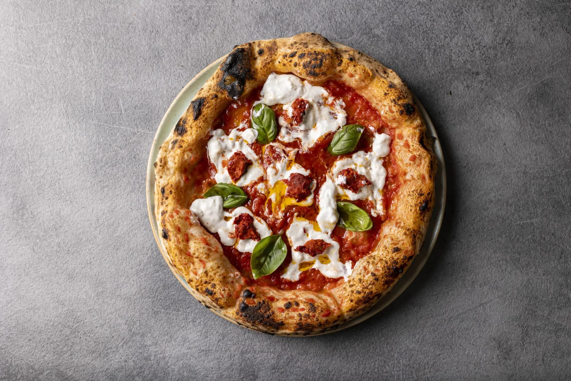 Pizza con burrata, pomodorini e basilico